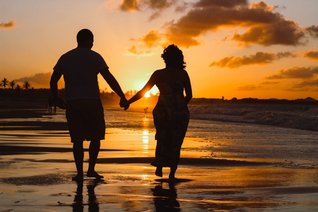 Image of couple on the beach where laughter, teamwork, and love turn into a celebration of togetherness when they learn about Taking a Break in Conversations  