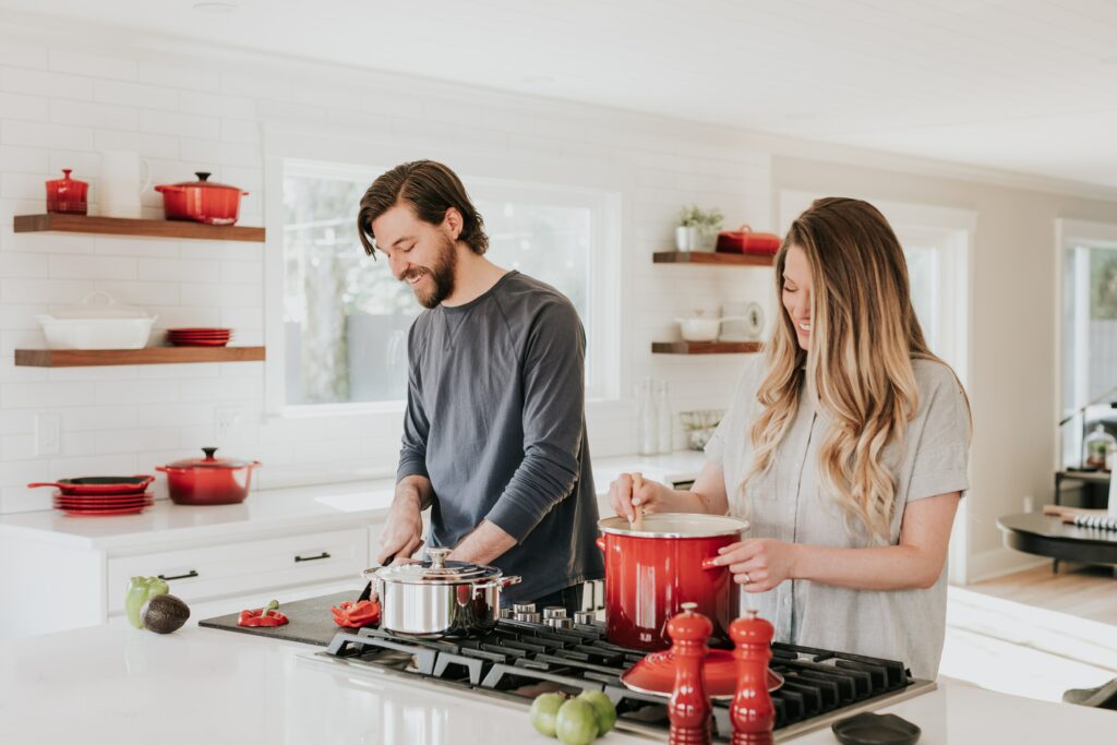 Image of couple in the kitchen, where laughter, teamwork, and love turn cooking into a celebration of togetherness when they learn about Taking a Break in Conversations  