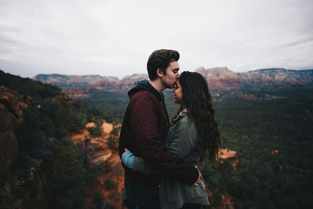 Image of a couple embracing against nature's grandeur, with arms wrapped around each other, they find solace and serenity exploring the 5 Ways to Support Mental Health in Relationships
